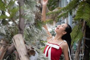 Portrait of teenage girl in a red dress relaxed and smiling in a snowy yard. photo