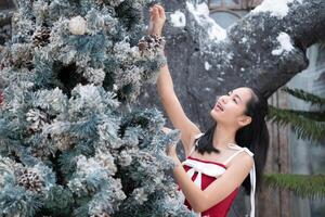 Portrait of teenage girl in a red dress relaxed and smiling in a snowy yard. photo