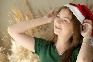 retrato de Adolescente niña con Papa Noel sombrero. foto