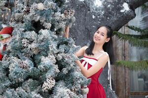 Portrait of teenage girl in a red dress relaxed and smiling in a snowy yard. photo