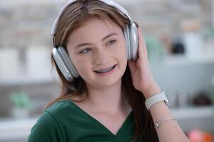 Portrait of Teenage girl listening to music with headphones and mobile phone. photo