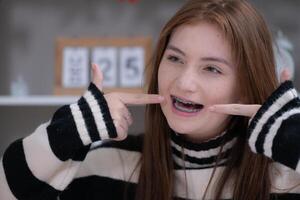 retrato de Adolescente muchachas con tirantes en su dientes foto