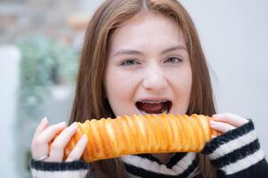 Portrait of Teenage girl eating bread in the kitchen at home photo