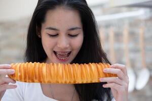 Portrait of Asian woman eating bread in the kitchen at home photo