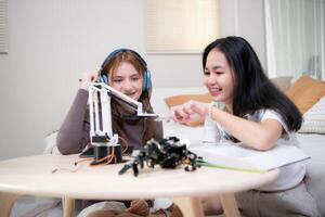 Portrait of Teenage girls students studying with robot model in the living room photo