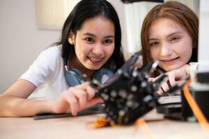 Portrait of Teenage girls students studying with robot model in the living room photo