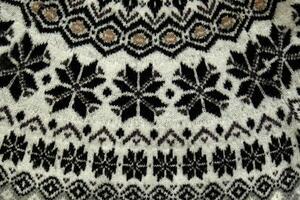 Black and white Winter Knitted Sweater Pattern Design with snowflakes. Handmade knitting wool fabric texture. Background of kniting patterns and ornament. photo