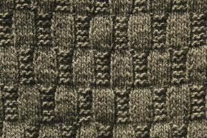 Background with gray knitted leaf shape, knitting pattern with cables. Top view, close-up. Handmade knitting wool photo