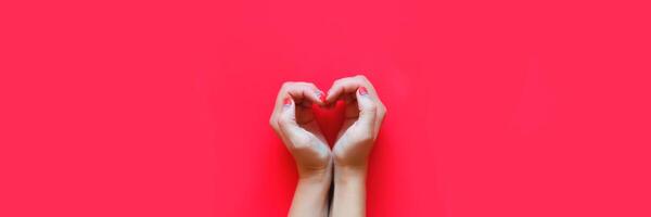 hands in the shape of a heart on a red background photo