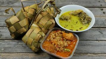 seleccionado atención ketupat Líbano, servido con sambal goreng kentang, opor ayam y telur semur. tradicional celebración menú durante eid al-fitr y eid al-adha en Indonesia foto