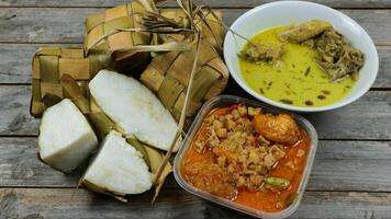 seleccionado atención ketupat Líbano, servido con sambal goreng kentang, opor ayam y telur semur. tradicional celebración menú durante eid al-fitr y eid al-adha en Indonesia foto