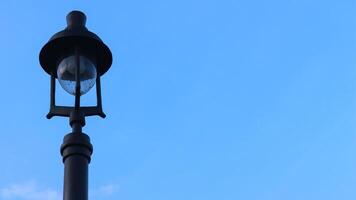 street lighting lights on city sidewalk with blue sky background. photo