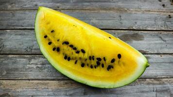 Yellow watermelon slices on wooden plate and isolated on gray board background. Healthy food, vegan. Antioxidant photo