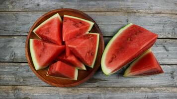 Red watermelon slices on wooden plate and isolated on gray board background. Healthy food, vegan. Antioxidant photo