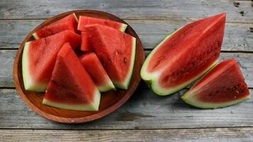 Red watermelon slices on wooden plate and isolated on gray board background. Healthy food, vegan. Antioxidant photo