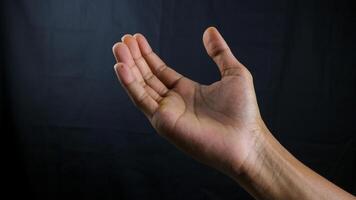 Human hand in choosing gesture isolate on white background with clipping path. Hand symbol reaching for something, A palm in front of black background photo