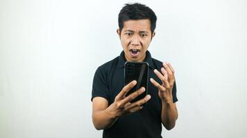 Disappointed, not expect, angry expression of asian man reading bad news at mobile phone isolated on white background. photo