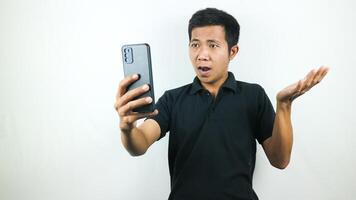 Disappointed, not expect, angry expression of asian man reading bad news at mobile phone isolated on white background. photo