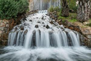 Long exposure artificial waterfall with stones photo