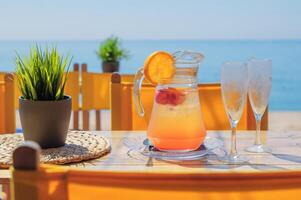 Pitcher of cold sangria served on the beach photo