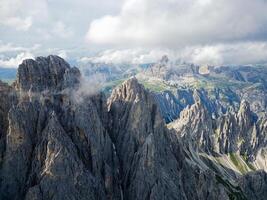 aéreo ver de cadini di misurina montañas con tre cime di lavaredo montañas en el antecedentes durante un soleado día con algunos nubes dolomitas, Italia. dramático y cinematográfico paisaje. foto