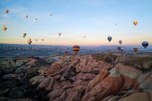 caliente aire globo vuelo en goreme en Turquía durante amanecer. paseo en un caliente aire globo, el más popular actividad en capadocia. romántico y famoso viaje destino. foto