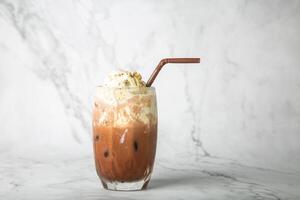 Iced cocoa  and vanilla ice cream on top in clear glass on marble photo