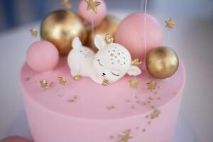 cumpleaños rosado pastel, decorado con merengue galletas en un gris antecedentes foto