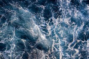 Top down aerial view of sea water surface. White foam waves texture as natural background. photo