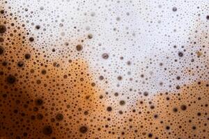 Textura superficial de café con leche caliente y espuma suave. foto