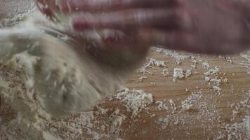 uomo cottura al forno pane. aspersione alcuni Farina su Impasto. scena. mani impasto Impasto. vicino su di mans mani impasto il Impasto nel ristorante video