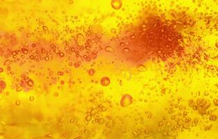 Abstract textured gel background. Yellow and orange liquid with bubbles. photo