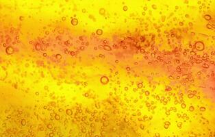 Abstract textured gel background. Yellow and orange liquid with bubbles. photo