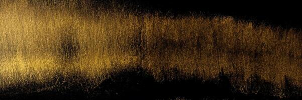 Golden traces of a stroke with an acrylic paint with an art brush on a black background. photo