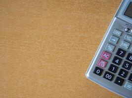 Close-up of a calculator on a wooden table with space for text photo