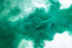 Green smoke bomb exploding against white background photo