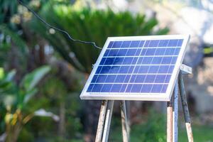 pequeño Talla solar células paneles en el jardín. instalación fotovoltaica para Proporcionar ligero a noche. concepto de energía y tecnología foto