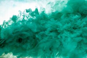 Green smoke bomb exploding against white background photo