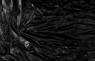 a transparent plastic wrap on black background. realistic plastic wrap texture for overlay and effect. wrinkled plastic pattern for creative and decorative design. photo