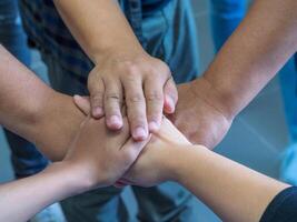 Close-up hands of friends joined together. Concept of unity and teamwork photo