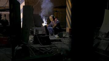 Worker with protective mask welding metal.welding in black background in slow motion. Man with protective mask welding metal in dark contrast background in slow motion video