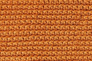Orange knitted fabric texture background. Top view. Copy, empty space for text photo