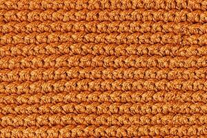 Orange knitted fabric texture background. Top view. Copy, empty space for text photo