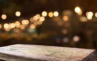 Empty wood table top on blur light gold bokeh of cafe restaurant in dark background photo