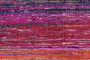 Cloth, typically produced by weaving or knitting textile fibers. Background and texture red old fabric. Closeup photo