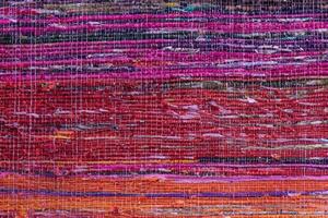 Cloth, typically produced by weaving or knitting textile fibers. Background and texture red old fabric. Closeup photo