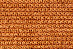 Orange knitted fabric texture background. Top view. Copy, empty space for text photo