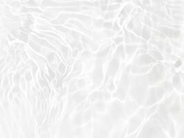 Defocus blurred transparent white colored clear calm water surface texture with splashes and bubbles. Trendy abstract nature background. Water waves in sunlight with copy space. White water shine photo