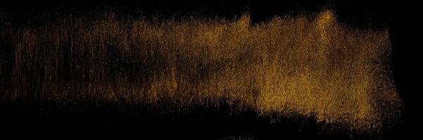 Golden traces of a stroke with an acrylic paint with an art brush on a black background. photo