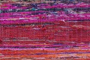 Cloth, typically produced by weaving or knitting textile fibers. Background and texture red old fabric. Closeup photo